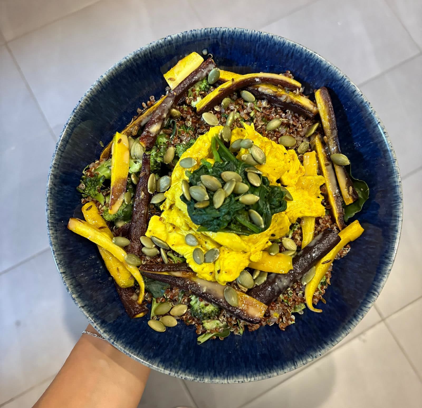 A chef-prepared quinoa bowl with roast carrots, broccoli and seeds