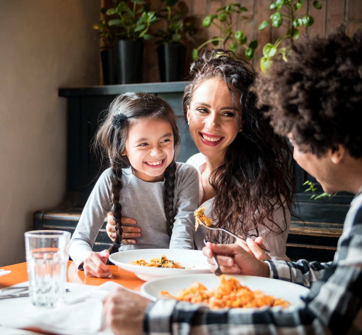 A family laughing together over lunch at a restaurant table
